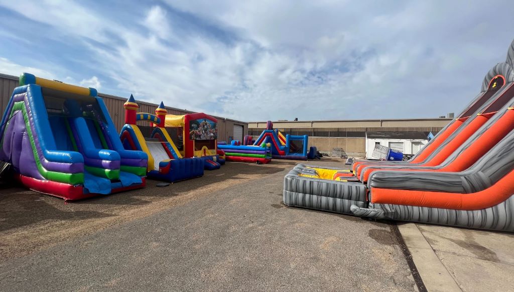 A business owner checks a wet/dry slide combo in a warehouse, ensuring it’s ready for rental